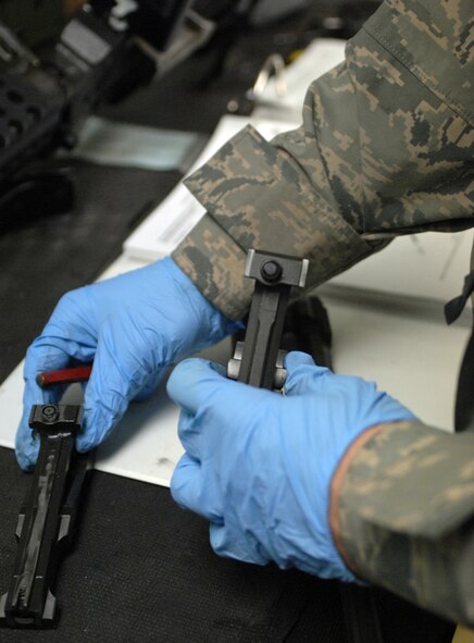 Senior Airman James Robinette, 2nd Security Forces Squadron, examines a broken part of a weapon at 2 SFS Combat Arms building on Barksdale Air Force Base, La., Jan. 26. Robinette is repairing an M-240B, a 7.62mm machine gun used to penetrate steel and engine blocks to prohibit unauthorized vehicle entry on installations. (U.S. Air Force photo/Airman 1st Class Joseph A. Pagán Jr.)(RELEASED)