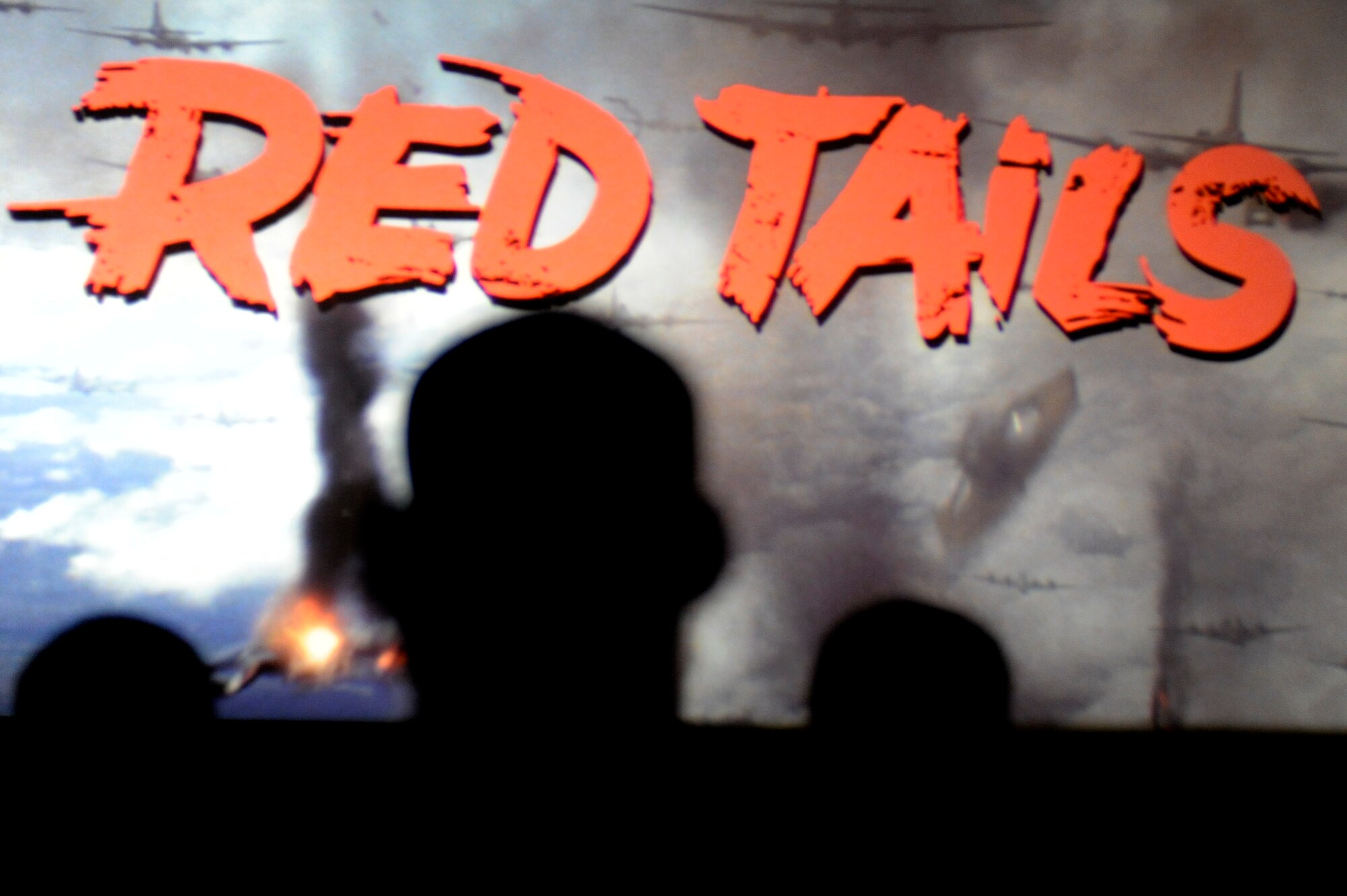 "Red Tails" flashes across the screen as members of the 332nd Air Expeditionary Wing watch the movie during its AOR premiere at an undisclosed location in Southwest Asia, Jan. 27, 2012. The movie is based on the Tuskegee Airmen, who were the first African American military aviators in the in the U.S. armed forces. Throughout their military career the Tuskegee Airmen accumulated many accolades including having 95 Distinguished Flying Crosses awarded to their personnel. (U.S. Air Force photo by Staff Sgt. Joshua J. Garcia/Released)