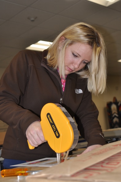 Danae Paul, Frame Shop customer, uses an adhesive gun on the matting for her project Dec. 29. Her and her husband were preparing frames to hold holiday pictures. “We went through the framing class a few years ago – this is a great opportunity to do hands-on work for yourself.” (U.S. Air Force photos by Scott King) 