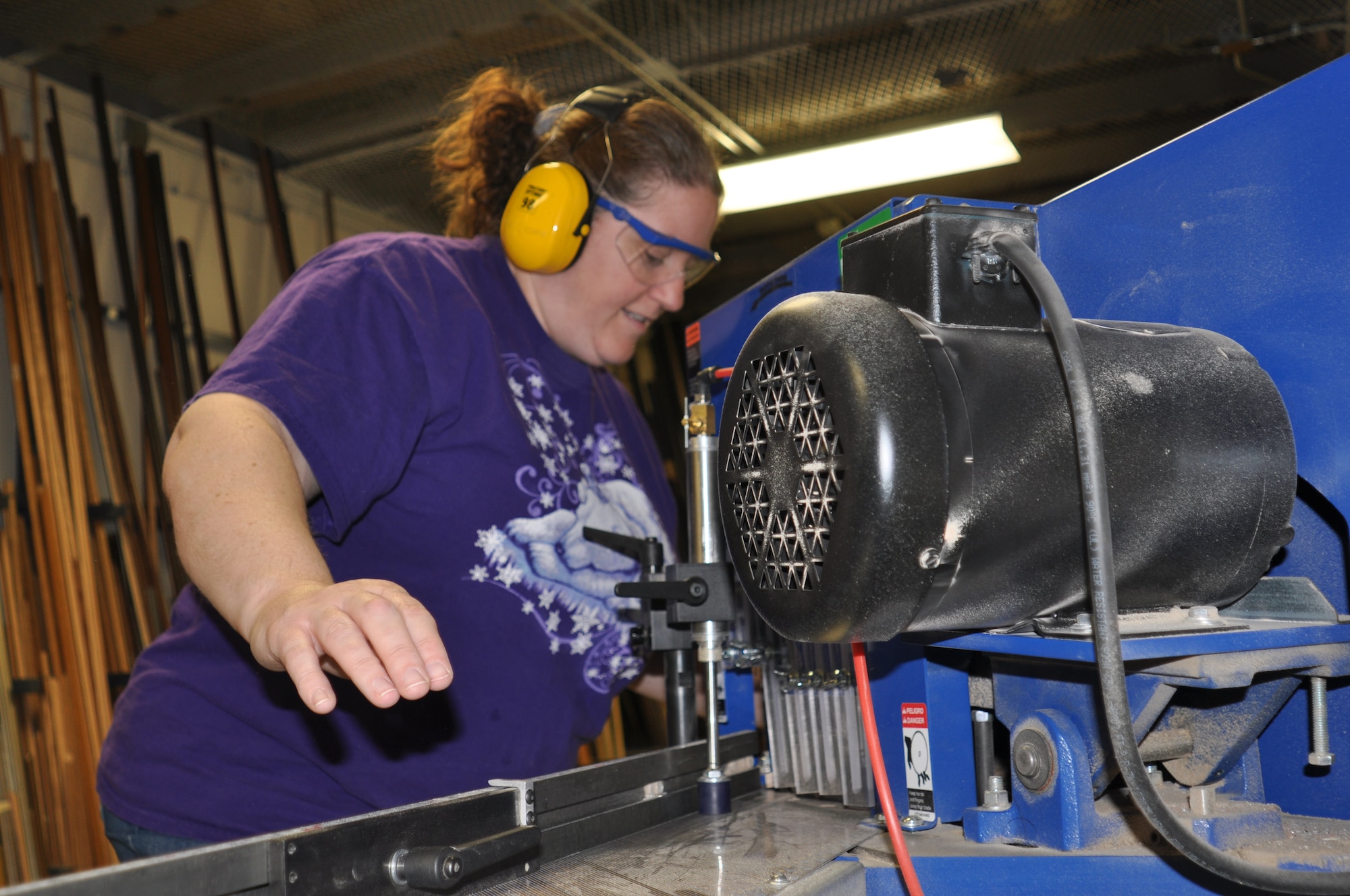 Tricia Attrill, Frame Shop customer, uses a saw to cut the wood for her frame Jan 4. She is making a frame for her kid’s pictures to give to her mother. “I took the framing class two weeks ago and so far I love making things on my own.” (U.S. Air Force photos by Scott King) 