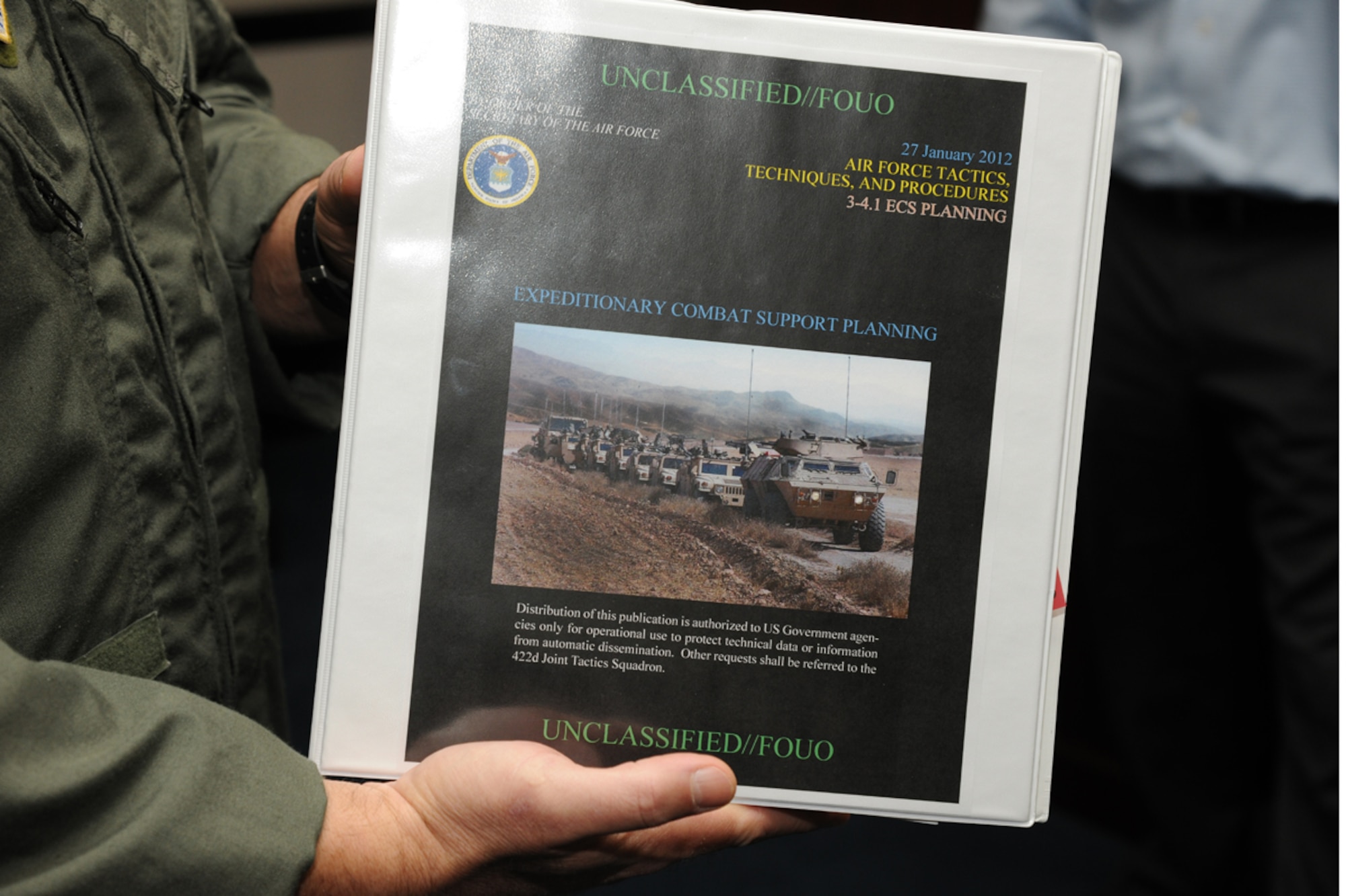 Lt. Col. Scott Robinson, 422nd Joint Tactics Squadron commander, holds up a copy of AFTTP 3-4.1, Expeditonary Combat Support Planning at the U.S. Air Force Expeditonary Center at Joint Base McGuire-Dix-Lakehurst, N.J.  The document serves a corss-functional playvbook to prepare, assess and analyze mission requirements for expeditonary combat support. (U.S. Air Force photo by Tech. Sgt. Zachary Wilson/Released)