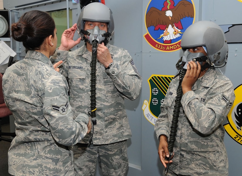 U.S. Air Force Fancia Bienvenue, 633rd Aerospace Medical Squadron aerospace and operational physiological technician, assists Chief Master Sgt. Steve Betancourt, 633rd Medical Group superintendent, and Airman 1st Class Alexis Shaw, 633rd Medical Support Squadron health services management technician, at the base altitude chamber during a Chief Shadow Day tour at Langley Air Force Base, Va., Jan. 26, 2012. Airmen shadowing the chiefs learned about the missions of different units on base from the perspective of upper-level leadership. (U.S. Air Force photo by Airman 1st Class Racheal Watson/Released) 