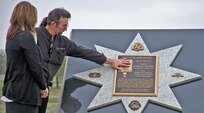 Melanie Sather, widow of Staff Sgt. Scott D. Sather, and step-father, Lucky Craft, pay their respects at the unveiling of Sather’s memorial. (U.S. Air Force photo/Senior Airman Marleah Miller)