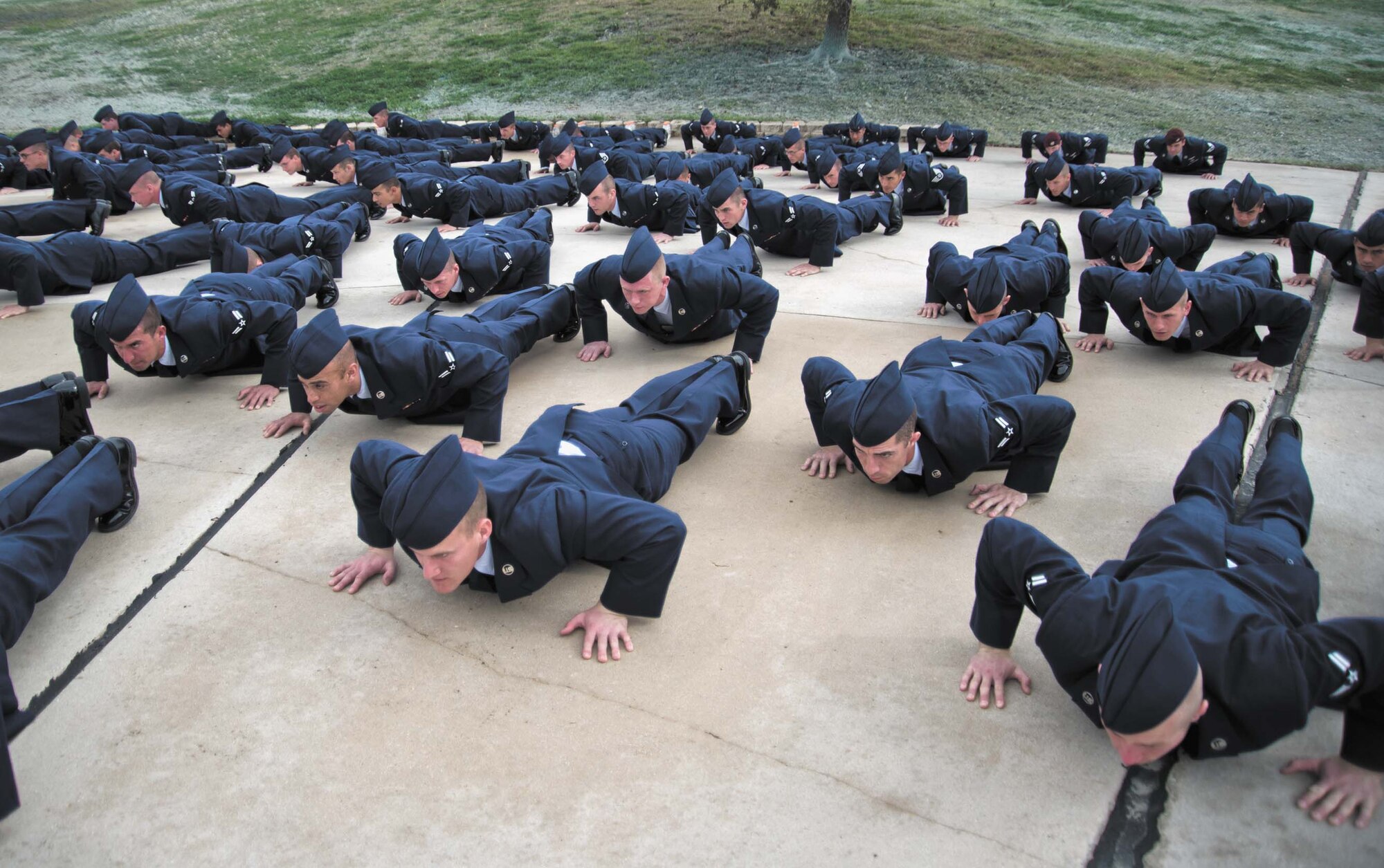 Pararescuemen, combat controllers and Pararescue Indoctrination Course trainees perform “memorial push-ups” during the memorial unveiling ceremony honoring Staff Sgt. Scott D. Sather Jan. 20 at the Joint Base San Antonio-Lackland Training Annex. Sather, a combat controller, was the first U.S. Air Force combat casualty during Operation Iraqi Freedom. Created by Air Force civil engineers, Sather’s memorial was displayed at Sather Air Base, near Baghdad International Airport, until its arrival here in October 2011. Sather AB has since transitioned from Air Force ownership and now falls under the Department of State as Sather Logistics Hub. (U.S. Air Force photo/Senior Airman Marleah Miller)