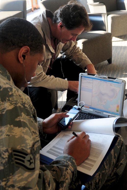 U.S. Air Force Staff Sgt. Oris Key, 633rd Security Forces Squadron patrolman, gathers information while Ken Hughes, Air Force Integrations Center systems engineer, checks the communication range of his cellular phone at Langley Air Force Base, Va., Jan. 25, 2012. A joint expeditionary force experiment exercise was held to provide better mobile solutions to meet the Air Force’s communication needs. (U.S. Air Force photo by Staff Sgt. Ashley Hawkins/Released)
