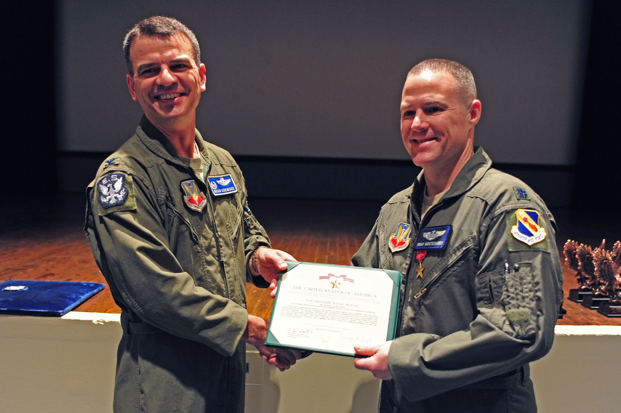 Lt. Col. Brian Montgomery receives a Bronze Star Medal from Col. Brian Kirkwood at the base theater on Seymour Johnson Air Force Base, N.C., Jan. 27, 2012. Montgomery earned the medal for his valor, service and leadership during Operation Enduring Freedom while deployed to Afghanistan. Montgomery is the 4th Fighter Wing inspections and exercises director, and Kirkwood is the 4th Operations Group commander. (U.S. Air Force photo/ Airman 1st Class Mariah Tolbert)