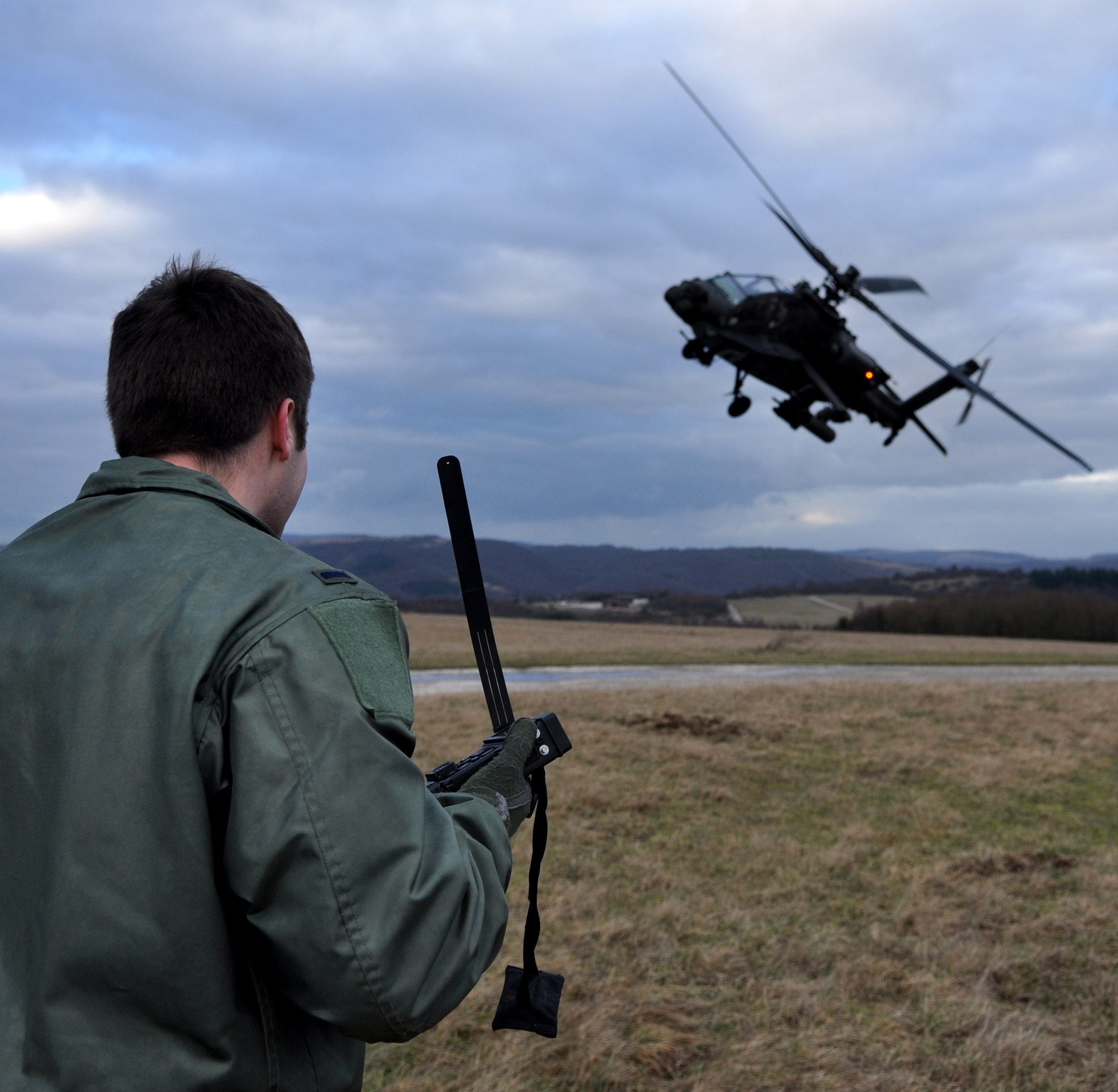 BAUMHOLDER, Germany – U.S. Air Force 1st Lt. Bob Carpenter, 81st Fighter Squadron pilot, uses a combat survivor evader locater radio to communicate that a U.S. Army AH-64 Apache helicopter that has arrived to rescue him during a joint training exercise at the Baumholder Major Training Area here Jan. 23. This training integrates U.S. Army and Air Force resources to more accurately simulate the real-life close air support and combat search and rescue scenarios encountered in deployed locations. The goal of this training is to develop tactics, techniques and procedures between military branches to enhance interoperability. (U.S. Air Force photo/Senior Airman Natasha Stannard)