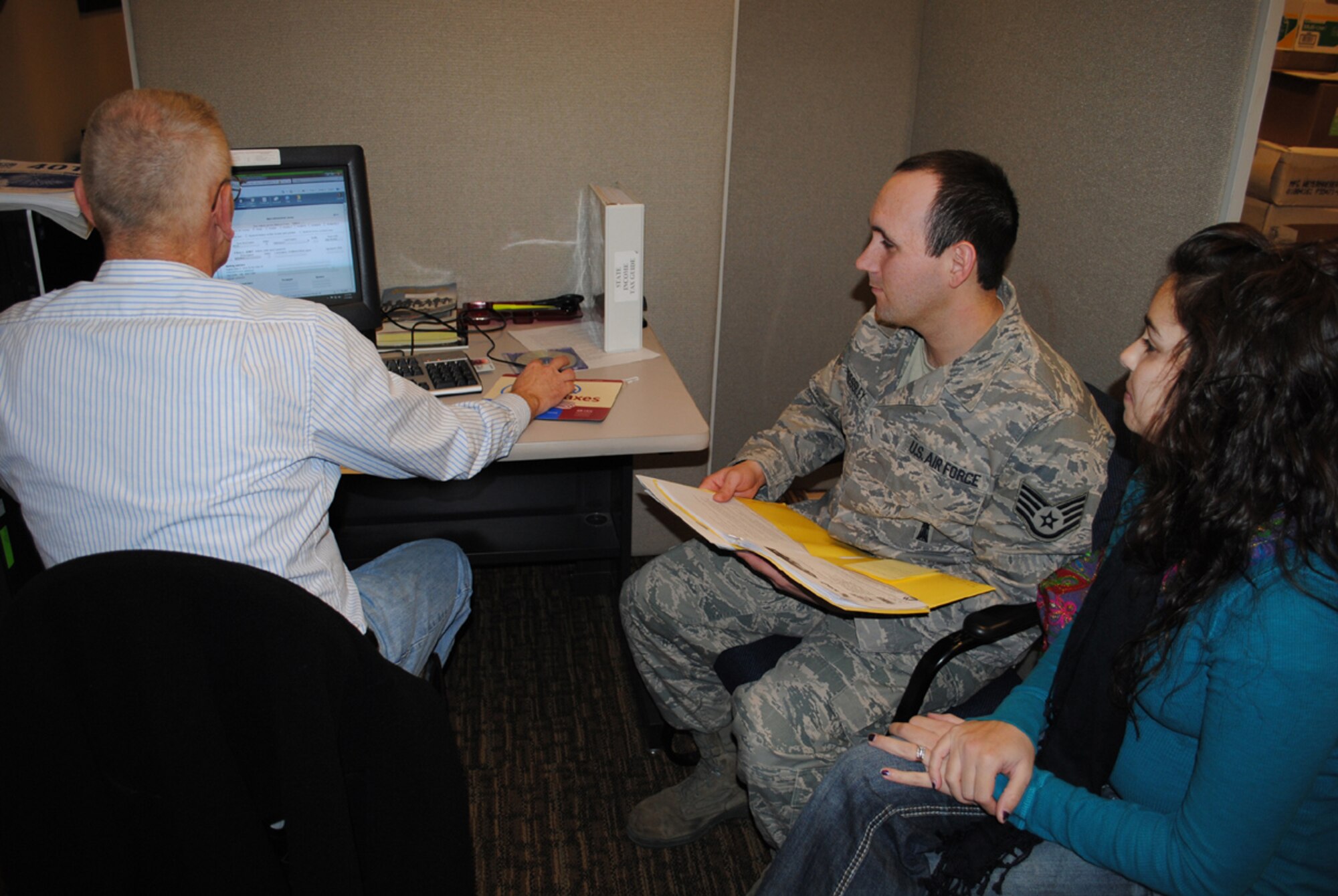 David Johnson, a tax center volunteer, helps prepare a tax return for Staff Sgt. Kyle Pressley, 341st Maintenance Group missile maintenance quality assurance, and his wife, Autumn. Free help with tax returns will be available for all active-duty members, Guardsmen, Reservists, retirees and their dependents, starting Jan. 30 at the tax center located in the Grizzly Bend. (U.S. Air Force photo/Airman Cortney Paxton)