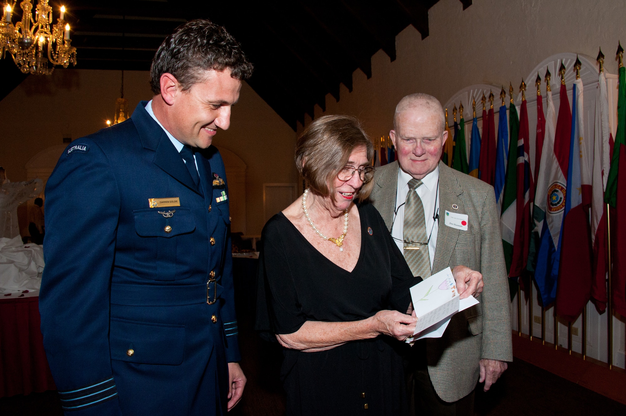 Wing Commander Darren Goldie of the Royal Australian air force, from left, watches as 40-class award recipients Dottye and Jim Hannan read a card of thanks crafted by his children. Volunteers who sponsor international officers during their studies at the Air University were honored with an awards ceremony Tuesday. (Air Force photo/Melanie Rodgers Cox)