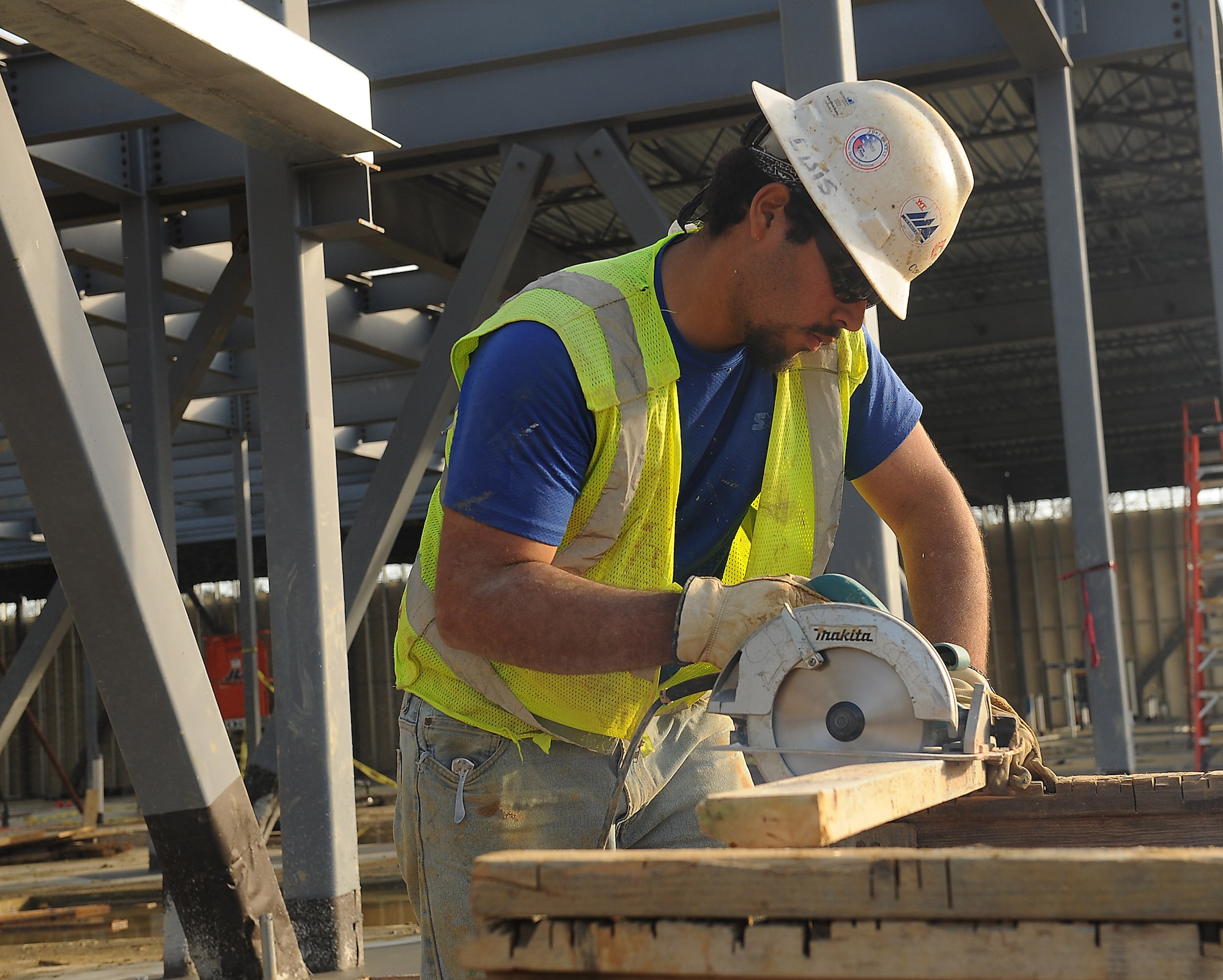Naim Romero, construction laborer, saws wood to use to secure the base of the AIT dining facility site at Fort Eustis, Va., Jan. 24, 2012. Scheduled to open this fall, this new facility will have a feeding capacity of up to 2,600 soldiers. (U.S. Air Force photo by Staff Sgt. Antoinette Gibson/Released)