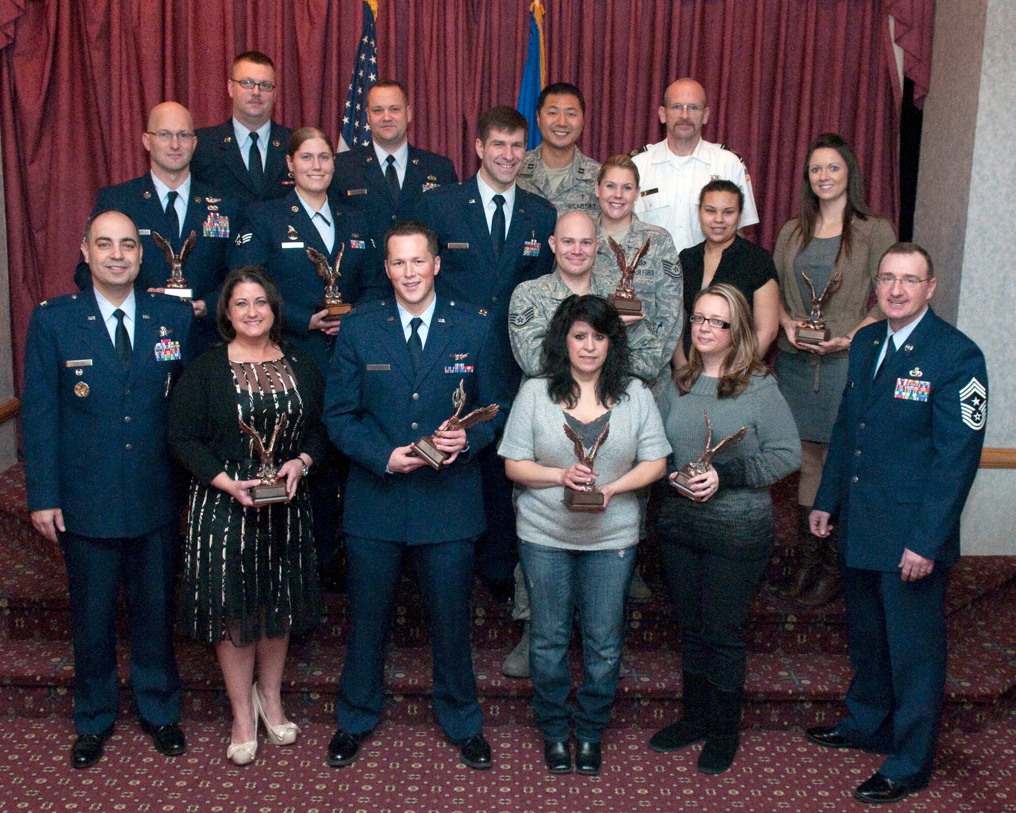 Col. George Farfour, 90th Missile Wing vice commander, and Chief Master Sgt. Marty Anderson, 90th MW command chief, pose for a photograph with the 2011 fourth quarter awards winners in the Trail’s End Club Jan. 19. The award winners are:  Senior Airman Adrienne Dunham, 90th Missile Security Forces Squadron; Tech. Sgt. William Shepherd, 90th Civil Engineer Squadron; Master Sgt. Harold Kruger, 37th Helicopter Squadron; Capt. Andrew Stevens, 90th Operations Support Squadron; Airman 1st Class Alexander Helling, 90th CES; Andrea Hull, 90th Medical Support Squadron; Melissa Battiste, 90th Contracting Squadron; Beverly Martinez, 90th Force Support Squadron; Greg Chesser, 90th CES fire department chief; the 90th Missile Wing Chaplain Corps; and Jennifer Stinson, wife of Lt. Col. Kiley Stinson, 90th Security Forces Group deputy commander. (U.S. Air Force photo by R.J. Oriez)