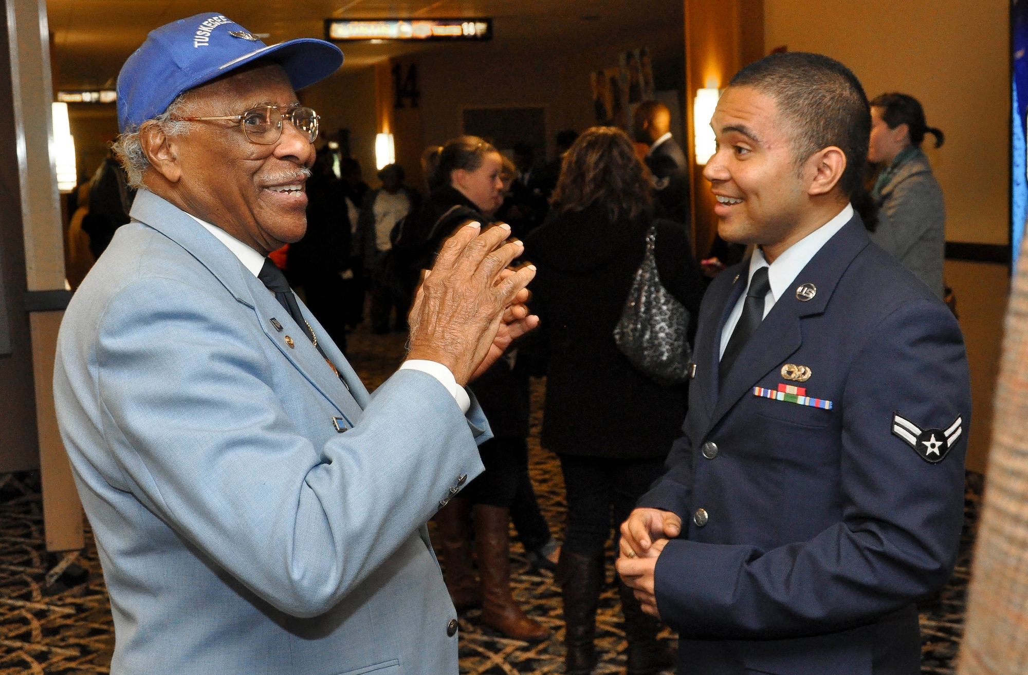 Retired Staff Sgt. Henry Moore, a Tuskegee Airman, shares a story with Airman First Class Christopher S. Good, a Gardinia, Calif. native and member of the 87th Logistics Readiness Squadron out of Joint Base McGuire-Dix-Lakehurst, on Jan. 17, 2012 at the United Artists King of Prussia Stadium 16 & Imax in King of Prussia, Pa. Moore was a crew chief for the 332nd Fighter Group, the unit depicted in the Red Tails, and worked at Ramitelli airfield, the location depicted in the movie. (Official U.S. Air Force photo by 2nd Lt. David J. Murphy/Released)