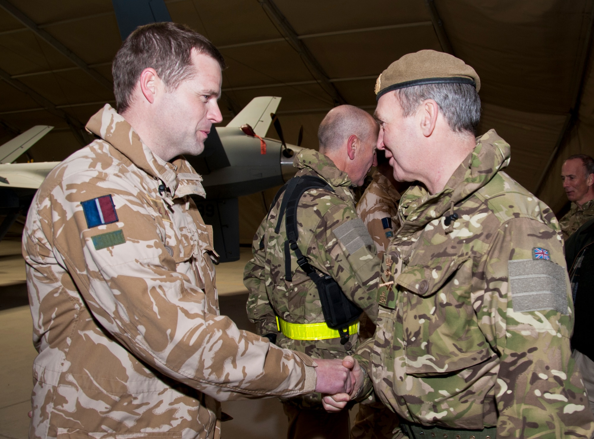 KANDAHAR AIRFIELD, Afghanistan -- From left, a member of the 62nd Expeditionary Reconnaissance Squadron meets Royal air force Gen. Nicholas Houghton, vice chief of defence staff, during the general’s visit to the 62nd ERS Jan. 23, 2012. The general and members of his staff toured the unit to understand the mission of the Royal air force members who are embedded in the 62nd ERS. (U.S. Air Force photo by Staff Sgt. David Carbajal)