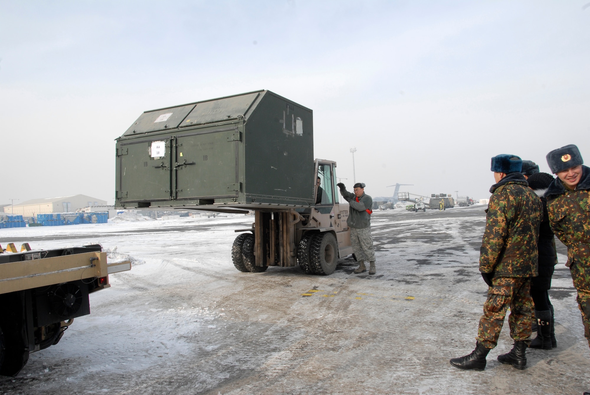 Members from the Kyrgyz Republic military watch as Airmen from the 376th Expeditionary Logistics Readiness Squadron demonstrate how they load cargo at the Transit Center at Manas, Kyrgyzstan, Jan. 26, 2012. Every month, United States and Kyrgyz military members get together to exchange information about their jobs and share differences and similarities. (U.S. Air Force photo/Senior Airman Lynsie Nichols)
