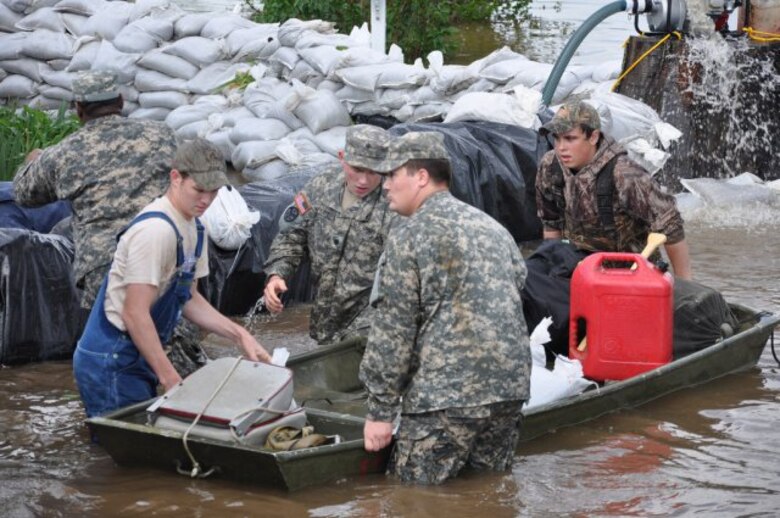 OSCAR, Ky. — Kentucky National Guard members Pfc. David Barrow, Spc. Tommy Wyatt and Pvt. Cedric Bransford, 2113th Transportation Company, assist local residents in flood relief mission here, April 27, 2011.