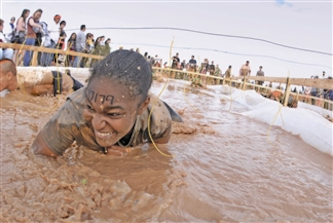 Senior Airman Danielle Sturdivant, with the 56th Communications Squadron at Luke Air Force Base, Ariz., crawls through the "electric eel" obstacle during the Tough Mudder at the Mesa Proving Grounds in Mesa, Ariz., on Jan. 14, 2012.  