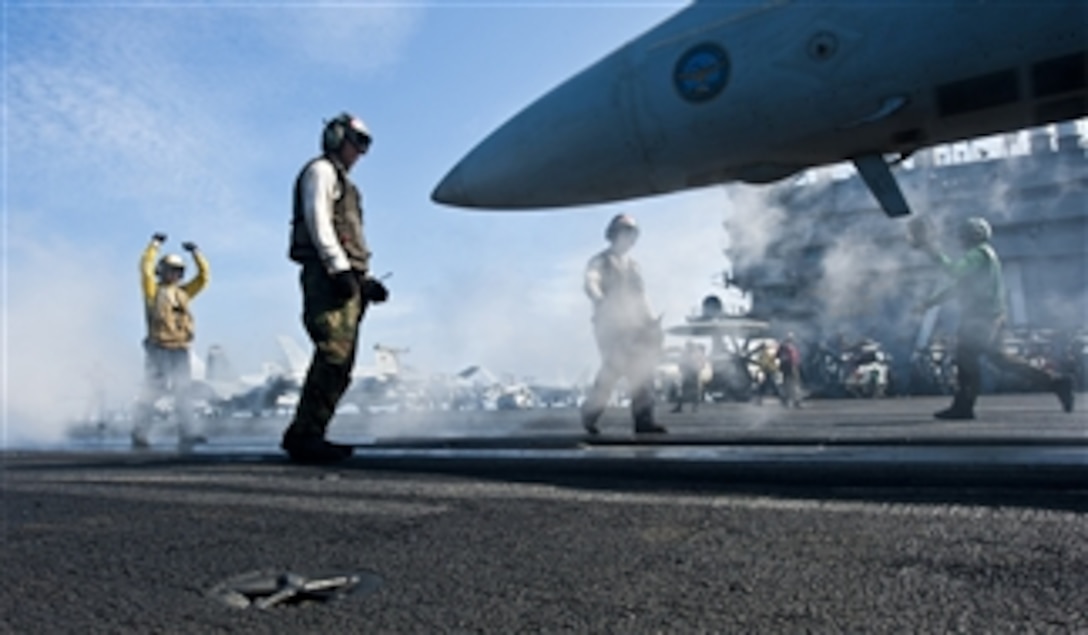 U.S. Navy Airman Michael Linscott directs an F/A-18E Super Hornet aircraft assigned to Strike Fighter Squadron 14 during flight operations on the flight deck of the aircraft carrier USS John C. Stennis (CVN 74) in the South China Sea on Jan. 24, 2012.  The John C. Stennis is operating in the U.S. 7th Fleet area of operations.  