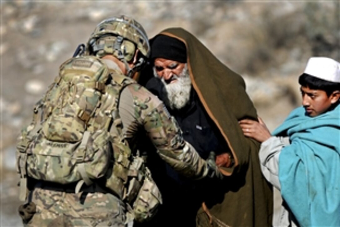 U.S. Army Sgt. Christian Aleman helps an elder seeking medical treatment during a combat patrol in Khowst province, Afghanistan, Jan. 25, 2012. Aleman is assigned to 2nd Battalion, 377th Parachute Field Artillery Regiment, Task Force Spartan Steel.