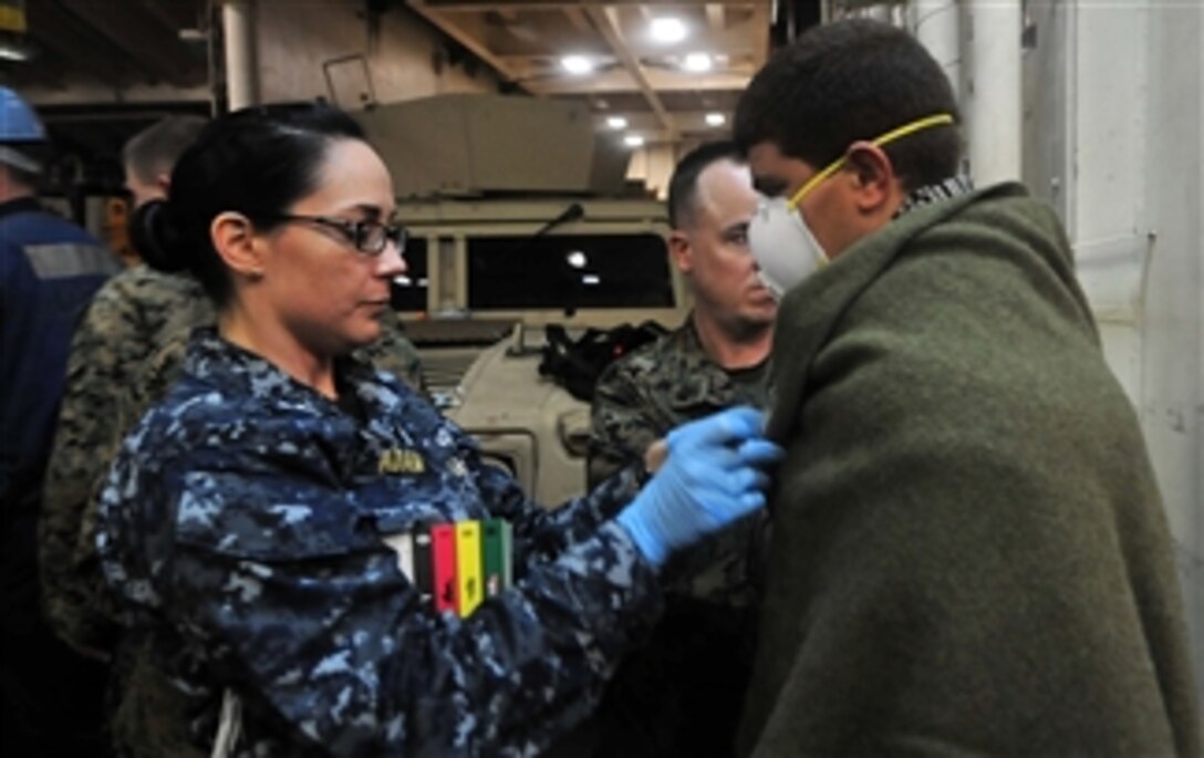 A U.S. Navy sailor provides medical care to a rescued Moroccan mariner aboard the amphibious transport dock ship USS Mesa Verde (LPD 19) in the Mediterranean Sea on Jan. 24, 2012.  Sailors assigned to the ship and embarked Marines with the 22nd Marine Expeditionary Unit picked up a group of Moroccans whose vessel had capsized three days earlier.  The Mesa Verde is deployed as part of the Bataan Amphibious Ready Group in support of maritime security operations and theater security cooperation efforts in the U.S. 6th Fleet area of responsibility.  