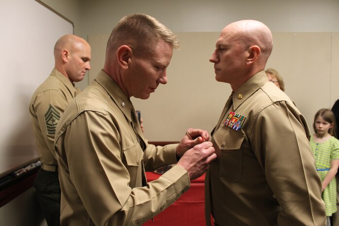 Major Jamie P. Murphy, the Wounded Warrior Regiment's future operations officer, is presented the Bronze Star Medal with Combat "V" device by Lieutenant Col. J.D. Harrill during an awards ceremony at the regimental headquarters here.  Murphy earned the Bronze Star for his heroic service in connection with combat operations against the enemy while serving in Operation Enduring Freedom.  Lieutenant Col. Harrill is the former commanding officer of 2nd Battalion, 8th Marines, Regimental Combat Team 1, 2nd Marine Division (Forward), where Murphy earned this honor.