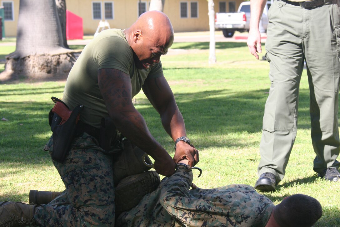 Sgt. Omar Askew, career planner, Headquarters and Service Battalion, finished the last station of the level one Oleoresin Capsicum spray course by apprenhending Lance Cpl. Andrew Rodgers, the "suspect" Jan. 27 aboard Marine Corps Recruit Depot San Diego. To complete the course the Marines had to complete five stations while having OC spray in their eyes. This course was to teach the Marines the effects of the spray and how to fight through the pain.