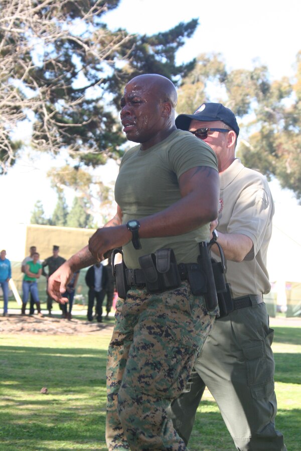 Sgt. Omar Askew, career planner, Headquarters and Service Battalion, is escorted to wash his eyes out after finishing the last station of the level one Oleoresin Capsicum spray course Jan. 27 aboard Marine Corps Recruit Depot San Diego. To complete the course the Marines had to complete five stations while having OC spray in their eyes. This course was to teach the Marines the effects of the spray and how to fight through the pain.