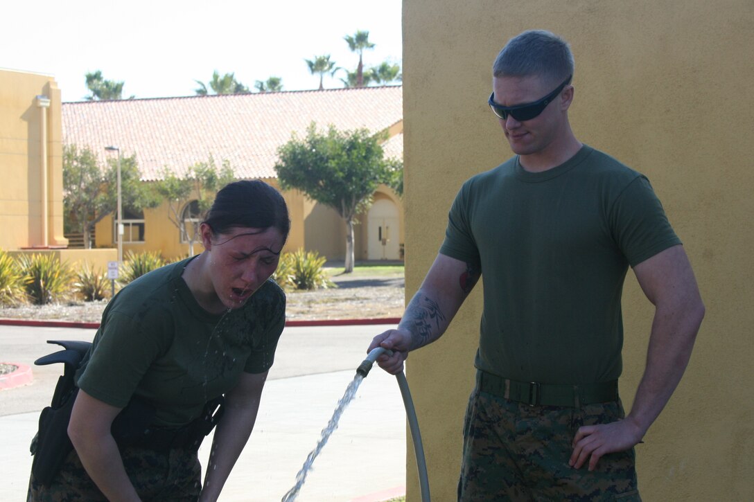 Lance Cpl. Bridget Keane, combat correspondant, Headquarters and Service Battalion, washes her eyes out after completing level one Oleoresin Capsicum spray course Jan. 27 aboard Marine Corps Recruit Depot San Diego. The Marines completed this course as a part of their Security Augmentation Force training. This course was to teach the Marines first hand the effects of the spray and how to fight through the pain.