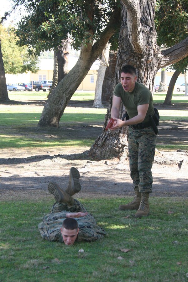 Lance Cpl. Joshua Franco, administrative clerk, Headquarters and Service Battalion, demonstrates apprehension of the "suspect" Lance Cpl. Andrew Rodgers, during a level one Oleoresin Capsicum spray for Security Augmentation Force training Jan. 27 aboard Marine Corps Recruit Depot San Diego. All the Marines that participated in the course were required to complete five stations while having OC spray in their eyes. The course was meant to give the Marines a first hand experience on the effects of OC spray.
