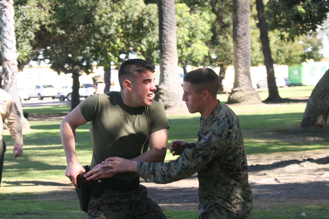 Lance Cpl. Joshua Franco, administrative clerk, Headquarters and Service Battalion, demonstrates weapon retention as the "suspect" Lance Cpl. Andrew Rodgers tried to take his gun, during a level one Oleoresin Capsicum spray for Security Augmentation Force training Jan. 27 aboard Marine Corps Recruit Depot San Diego. All the Marines that participated in the course were required to complete five stations while having OC spray in their eyes. While standing SAF the Marines will be carrying OC spray and needed to learn the effects, when to use it and how to use the spray.