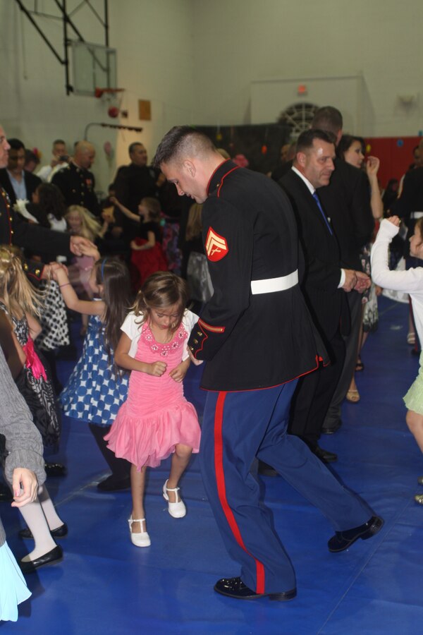 Cpl. David Clark, adminstration clerk, 12th Marine Corps District, accompanies his daughter on the dance floor at the Father Daughter Dance in the Semper Fit Fieldhouse aboard Marine Corps Recruit Depot San Diego Jan. 27. The fifth annual Father Daughter Dance was themed Sugar, Spice and Everything Nice and attracted 194 guests.