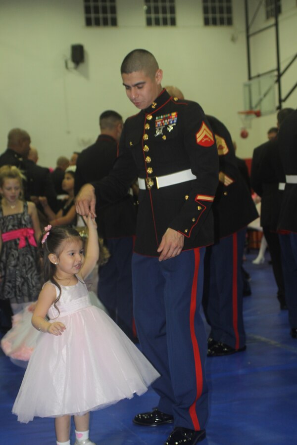Cpl. Luis Rosas, supply clerk, Headquarters Company, Headquarters and Service Battalion, accompanies his daughter on the dance floor at the fifth annual Father Daughter Dance in the Semper Fit Fieldhouse aboard Marine Corps Recruit Depot San Diego Jan. 27. The tables were lined with sweets to go along with the theme Sugar, Spice and Everything Nice.