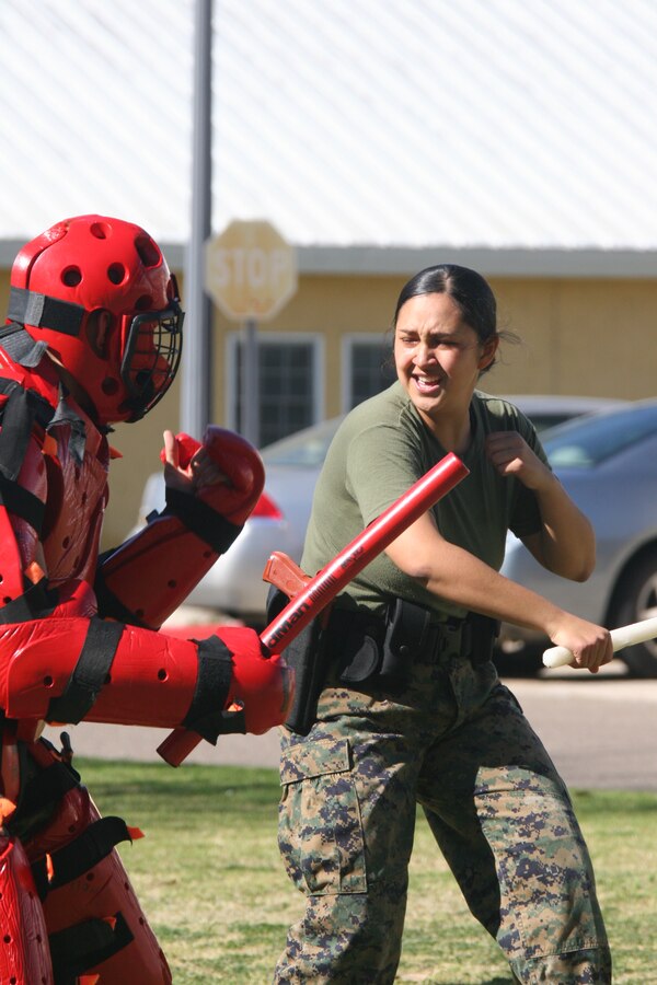 Lance Cpl. Chae Williams, correspondent clerk, Headquarters and Service Battalion, delivers baton strikes and blocks so that she can subdue the "suspect" Jan. 27 during a level one of Oleoresin Capsicum spray course aboard Marine Corps Recruit Depot San Diego. Marines completed this course as a part of Security Augmentation Force training. This gave them a first hand experience on the OC spray effects and situations they may face.