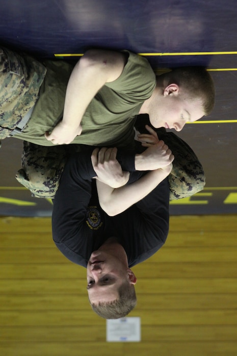 Sgt. Kyle C. Hill, Headquarters and Headquarters Squadron Special Reaction Team team leader and Auxiliary Security Forces instructor, demonstrates the proper application of a hold on the arm of Lance Cpl. Paul J. Halter, H&HS SRT member during ASF training at the IronWorks Gym sports courts here Jan. 27. Approximately 34 Marines took part in the training coming from various shops within the squadron.