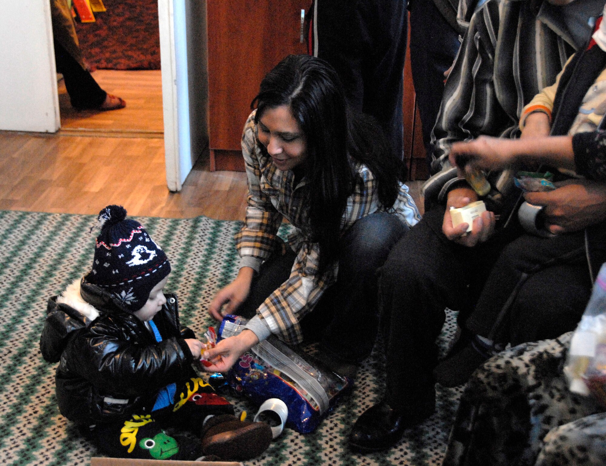 Tech. Sgt. Gloria Casanova, 376th Expeditionary Communications Squadron helpdesk NCO in charge, deployed from Little Rock Air Force Base, Ark., shares candy with 2-year-old Sardor at the Children's Cancer Center in Bishkek, Kyrgyzstan, Jan. 25, 2012. "Taking time out of my schedule to spend quality time with these children is worth it to me," she said. "The simple smile we put on every child there makes me want to do more for the children and make the center a better place for them." (U.S. Air Force photo/Senior Airman Lynsie Nichols)