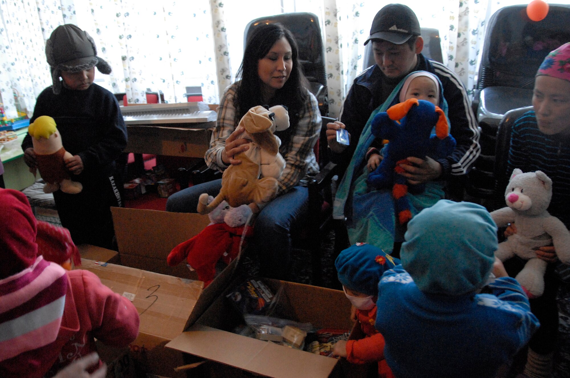 Tech. Sgt. Gloria Casanova, 376th Expeditionary Communications Squadron helpdesk NCO in charge, deployed from Little Rock Air Force Base, Ark., shares stuffed animals with a Kyrgyz man and his child at the Children's Caner Center in Bishkek, Kyrgyzstan, Jan. 25, 2012. ?It amazes me how much life these kids have in them and how smart they are,? she said. ?The kids light up when we visit the center, it melts my heart thinking about the impact we are making on them.? (U.S. Air Force photo/Senior Airman Lynsie Nichols)