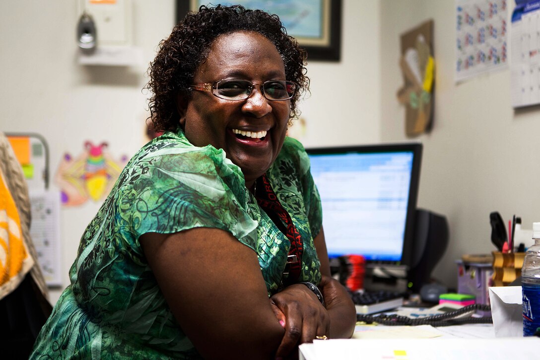 Jeannette E. Powell-Campbell, assistant adjutant, Headquarters and Service Battalion, U.S. Marine Corps Forces, Pacific, flashes that familiar smile in her office here Jan. 30. Powell-Campbell is a retired master gunnery sergeant who is the adopted mother of three Cambodian children.