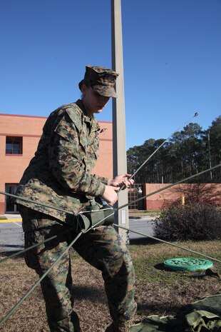 Lance Cpl. Sharmin West, a field radio operator with Marine Wing Communications Squadron 28, assembles an OE-254 biconical antenna during operation Grizzly Spartan Jan. 30. West said this wasn’t the first time she’s assembled the antenna and can put it all together in approximately eight minutes.::r::::n::::r::::n::