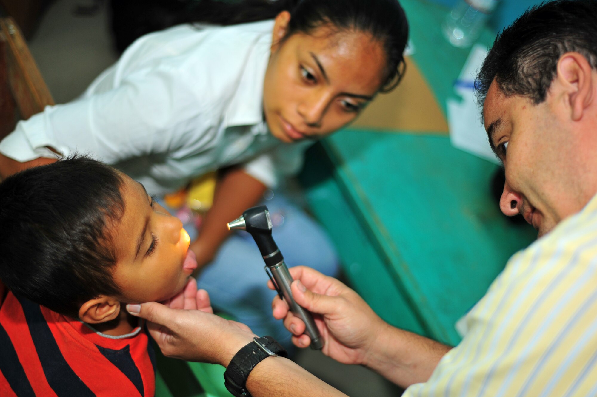 OLANCHO, Honduras – Dr. Carlos Duron, a Medical Element Liaison Officer, exams the throat of an Olancho District child during the second day of a Joint Medical Readiness Training Exercise here. Members from the Honduran Ministry of Health, the Honduran military and Joint Task Force-Bravo, Soto Cano Air Base, Honduras, provided medical services to more than 280 members of the local area Jan. 30. (Air Force photo/Staff Sgt. Bryan Franks) 


