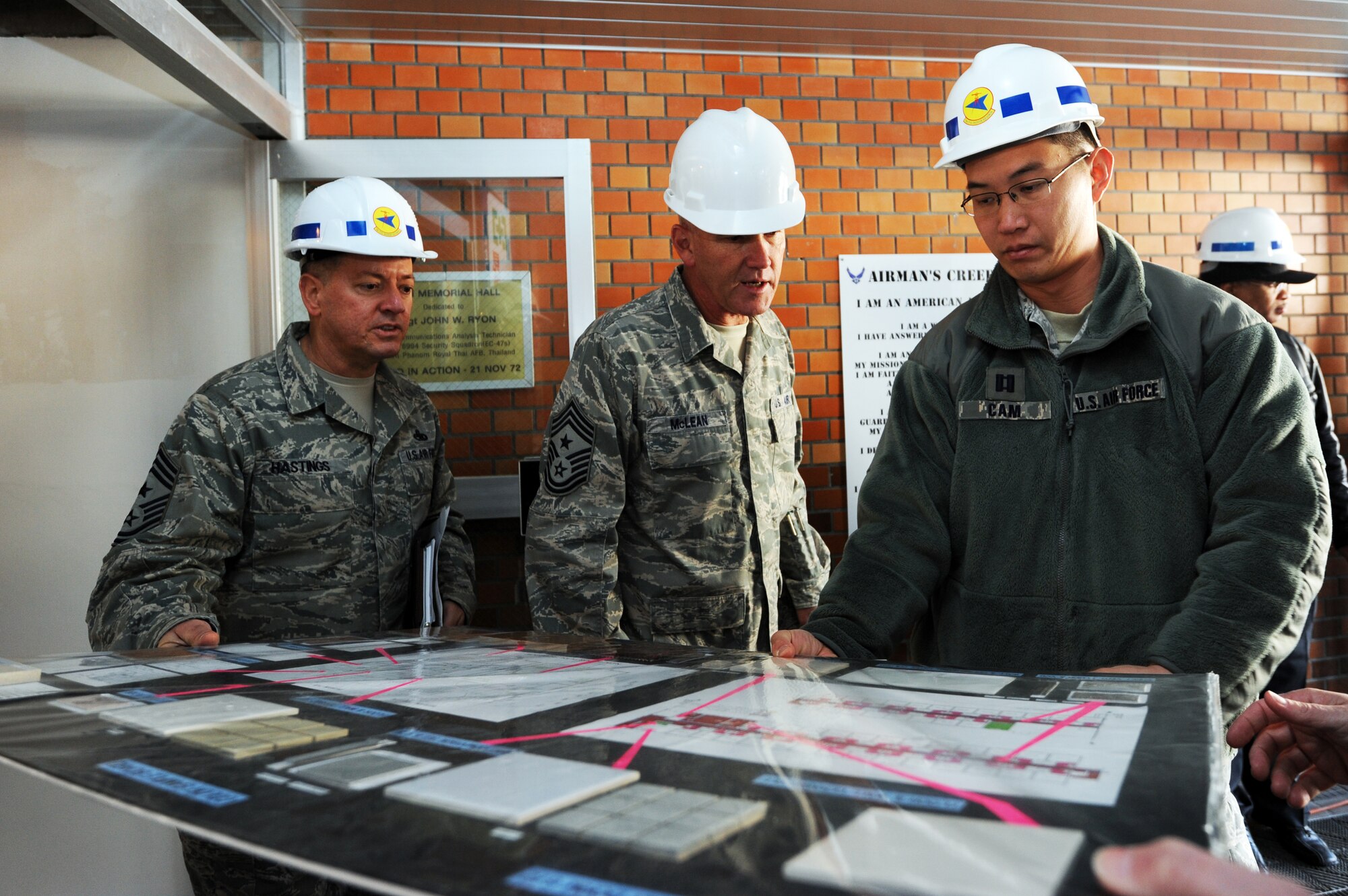 MISAWA AIR BASE, Japan -- Chief Master Sgt. Russell Hastings, left, 35th Fighter Wing command chief, Chief Master Sgt. Brooke McLean, Pacific Air Forces command chief, and Captain Ricky Cam, 35th Civil Engineer Squadron chief of programs flight, look over the plans for Dormitory 672, here Jan. 25. Renovations in Dormitory 672 increased bed spaces from 98 to 196 beds. (U.S. Air Force Photo/Airman 1st Kia Atkins)