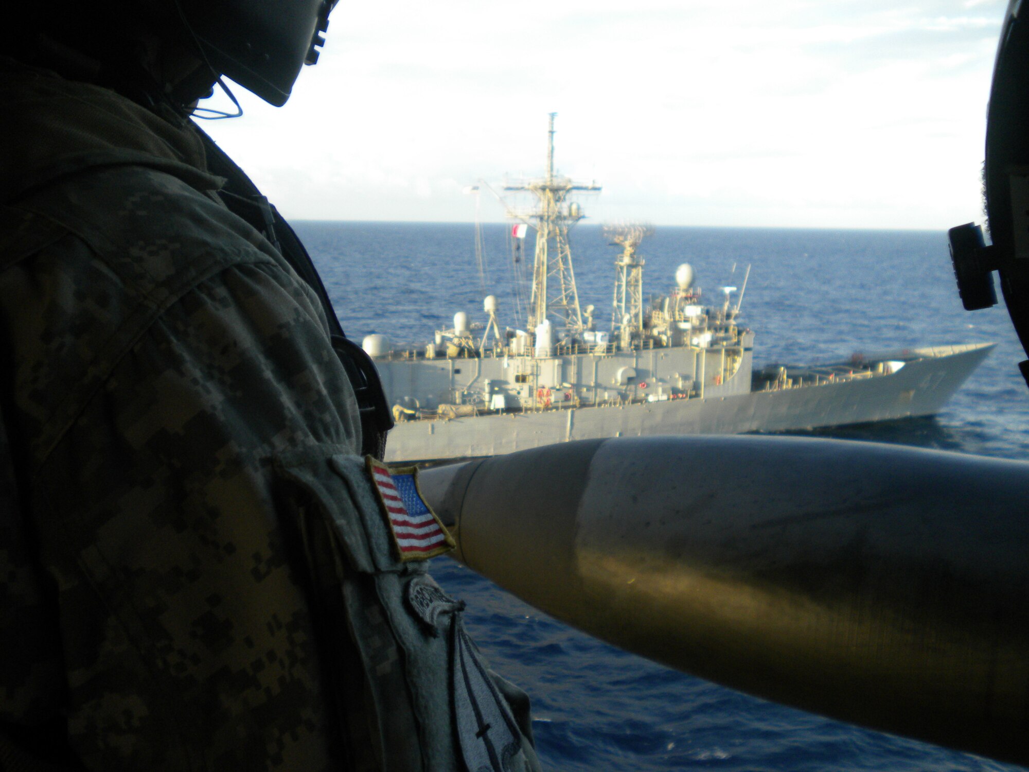 GUANAJA ISLAND, Honduras - A soldier observes the USS Nicholas as the UH-60 Blackhawk pilots, 1st Battalion, 228th Aviation Regiment, Soto Cano Air Base, Honduras, make their final pass here Jan. 25. Eight JTF-Bravo pilots completed five consecutive bounces, which are landings, liftoffs, circling then repeating the process. It takes approximately 30 minutes for each pilot to complete the deck-landing qualification. In total, 11 crew members qualified and now the battalion has four-qualified crews. This training increases the unit's ability to provide humanitarian assistance and disaster relief as well as enhances its' medical evacuation capability. (U.S. Army photo/Capt. David Zupancic)