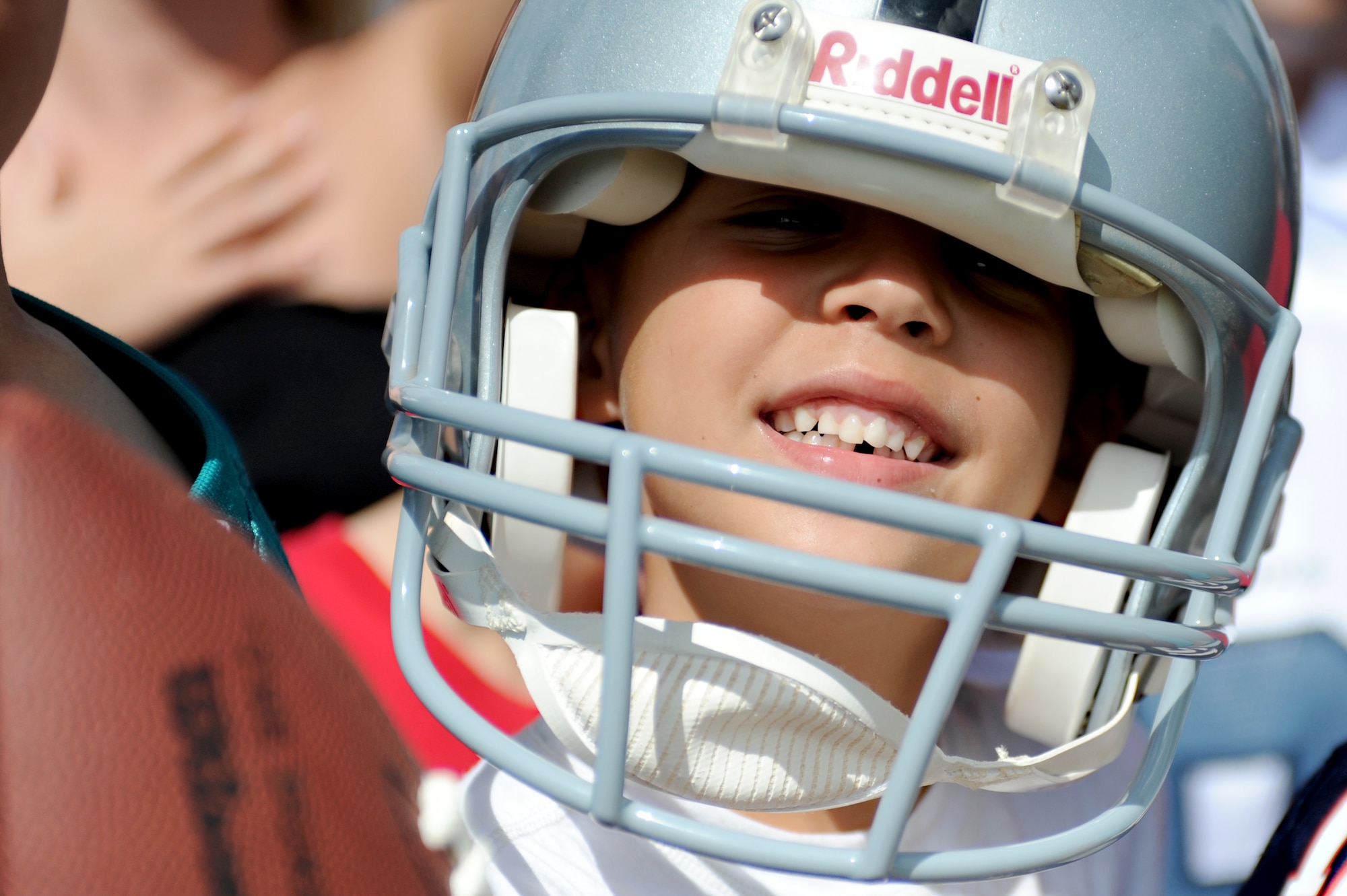A young football fan wears his Oakland Raiders helmet in hopes that one of the professional football players would walk over and sign it for him during the Pro Bowl practice Jan. 26, 2012, at Earhart Field on Joint Base Pearl Harbor-Hickam, Hawaii. Hundreds of service members and their families gathered at the field with the same hopes by bringing a grocery list of sports memorabilia. (U.S. Air Force photo/Staff Sgt. Mike Meares)