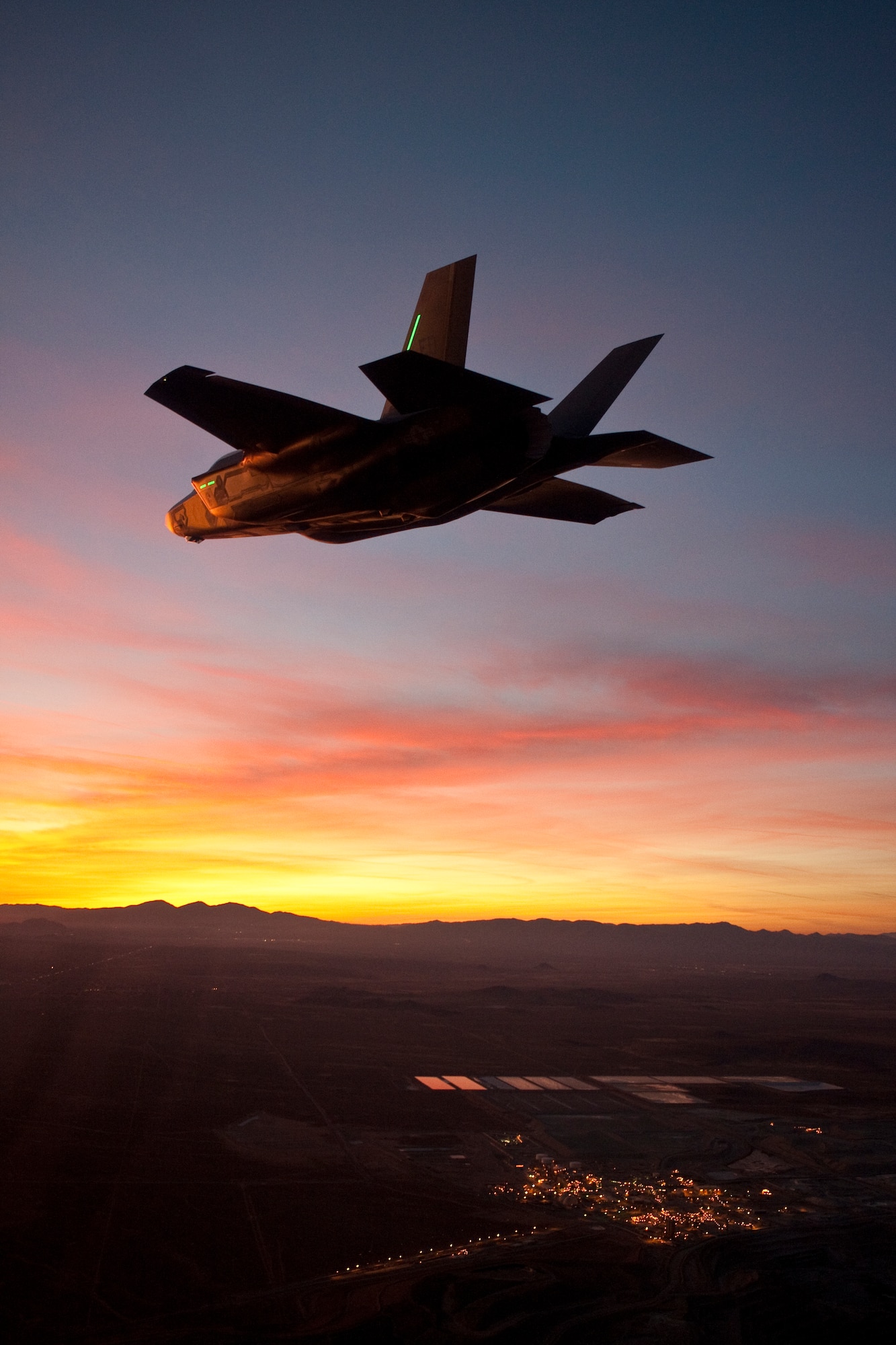 An F-35A soars during twilight over the Antelope Valley as part of the program’s first night fight test, Jan. 18. The 461st Flight Test Squadron, along with the Joint Strike Fighter Integrated Test Force, conducted the test to verify the aircraft’s lighting capabilities at night. (Lockheed Martin photo by Tom Reynolds)