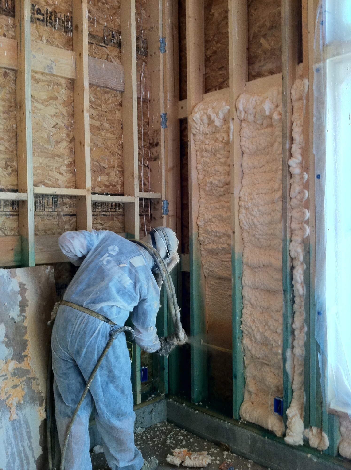 SAN ANTONIO, Texas -- A worker sprays foam into the walls of the addition to AFCEE employee Erica Becvar's home to improve the room's energy efficiency. Courtesy photo