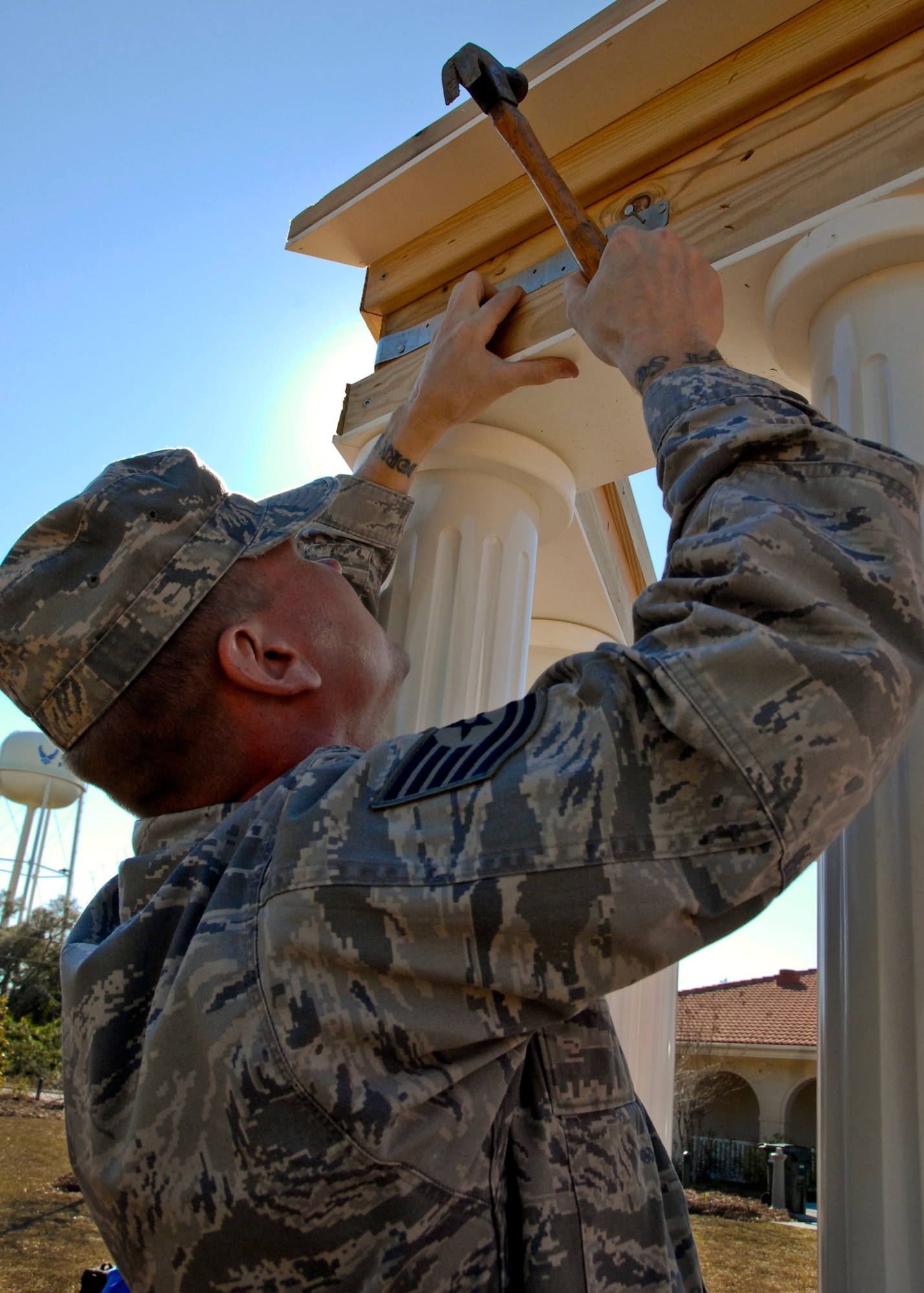 Tech. Sgt. Shannon Calhoun, a member of the 33rd Aircraft Maintenance Squadron, hammers support braces under the new Fisher House gazebo’s roof Jan. 27.  The $10,000, 10- by 20-foot gazebo was donated by retired Air Force Col. Bill Mann and his family.  The Fisher House is one of a network of donated comfort homes built on major military bases and Veterans Administration centers, where families can stay while a loved one is receiving medical treatment.  (U.S. Air Force photo/Kevin Gaddie) 
