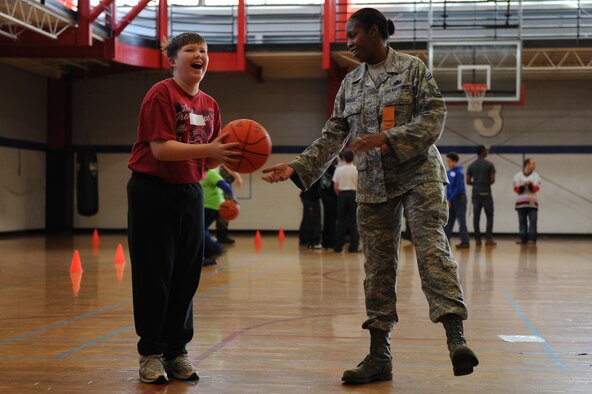 Senior Master Sgt. Lasauna Nolan-Tucker hands the ball back to Willy Vanduyne, 11, during the Wayne County Special Olympics basketball games in Goldsboro, N.C., Jan. 25, 2012. Due to the number of participants in this county, Special Olympic events take three days, which accommodates the adult population and elementary, middle school and high school students. Nolan-Tucker, 916th Force Support Squadron Airman and family services chief, is from Galveston, Texas. Vanduyne attends Greenwood Middle School. (U.S. Air Force photo/ Staff Sgt. Courtney Richardson)