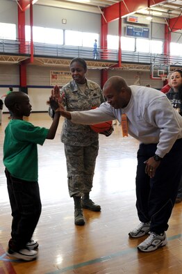 Maj. Michael Kearney and Senior Master Sgt. Lasauna Nolan-Tucker share a high-five with a participant at the Wayne County Special Olympics basketball games in Goldsboro, N.C., Jan. 25, 2012. The games provide the athletes an opportunity to gain self-confidence, social competence, greater athletic skills and higher self esteem. Kearney, 4th Logistics Readiness Squadron operations officer, is from Warrenton, N.C. Nolan-Tucker, 916th Force Support Squadron Airman and family services chief, is from Galveston, Texas. (U.S. Air Force photo/ Staff Sgt. Courtney Richardson)