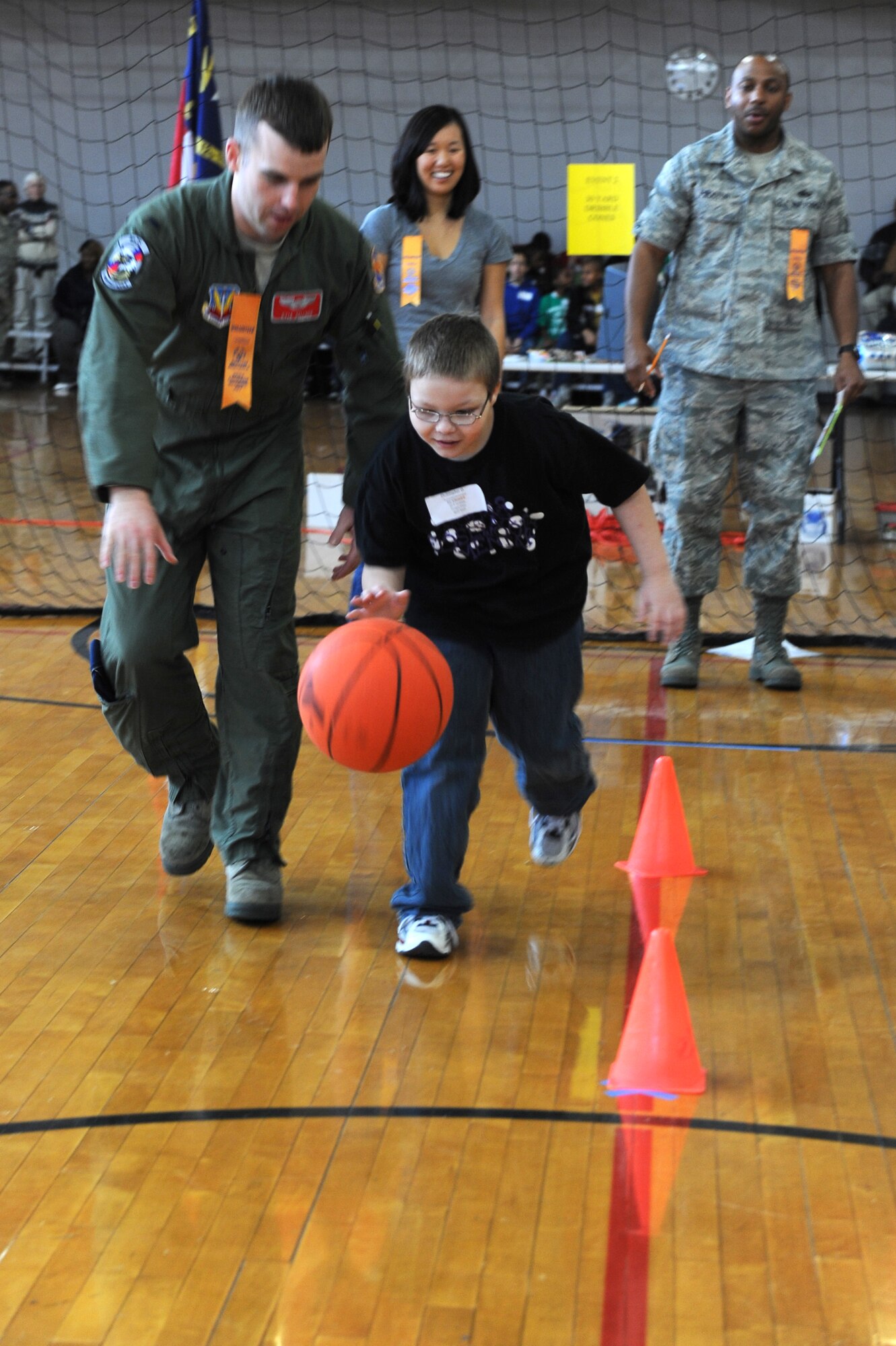 Lt. Kyle Sellner coaches Christopher O’Brien, 9, as he dribbles through an event at the Wayne County Special Olympics basketball games in Goldsboro, N.C., Jan. 25, 2012. Special Olympic events take place all every day, all around the world including local, national and regional competitions, totaling about 50,000 events a year. Sellner is from the 4th Training Squadron and hails from Waddell, Ariz. and O’Brien attends Rosewood Elementary School. (U.S. Air Force photo/Staff Sgt. Courtney Richardson)