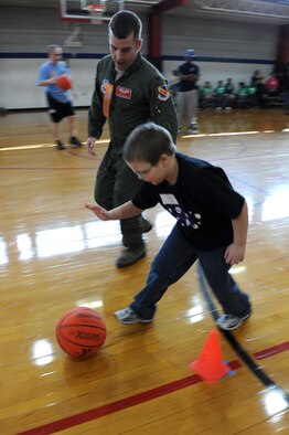 1st Lt. Kyle Sellner coaches Christopher O’Brien, 9, through a Wayne County Special Olympics basketball challenge in Goldsboro, N.C., Jan. 25, 2012. Special Olympic events take place every day, all around the world including local, national and regional competitions, totaling about 50,000 events annually. Sellner is from the 4th Training Squadron and hails from Waddell, Ariz. O’Brien attends Rosewood Elementary School. (U.S. Air Force photo/Staff Sgt. Courtney Richardson) 
