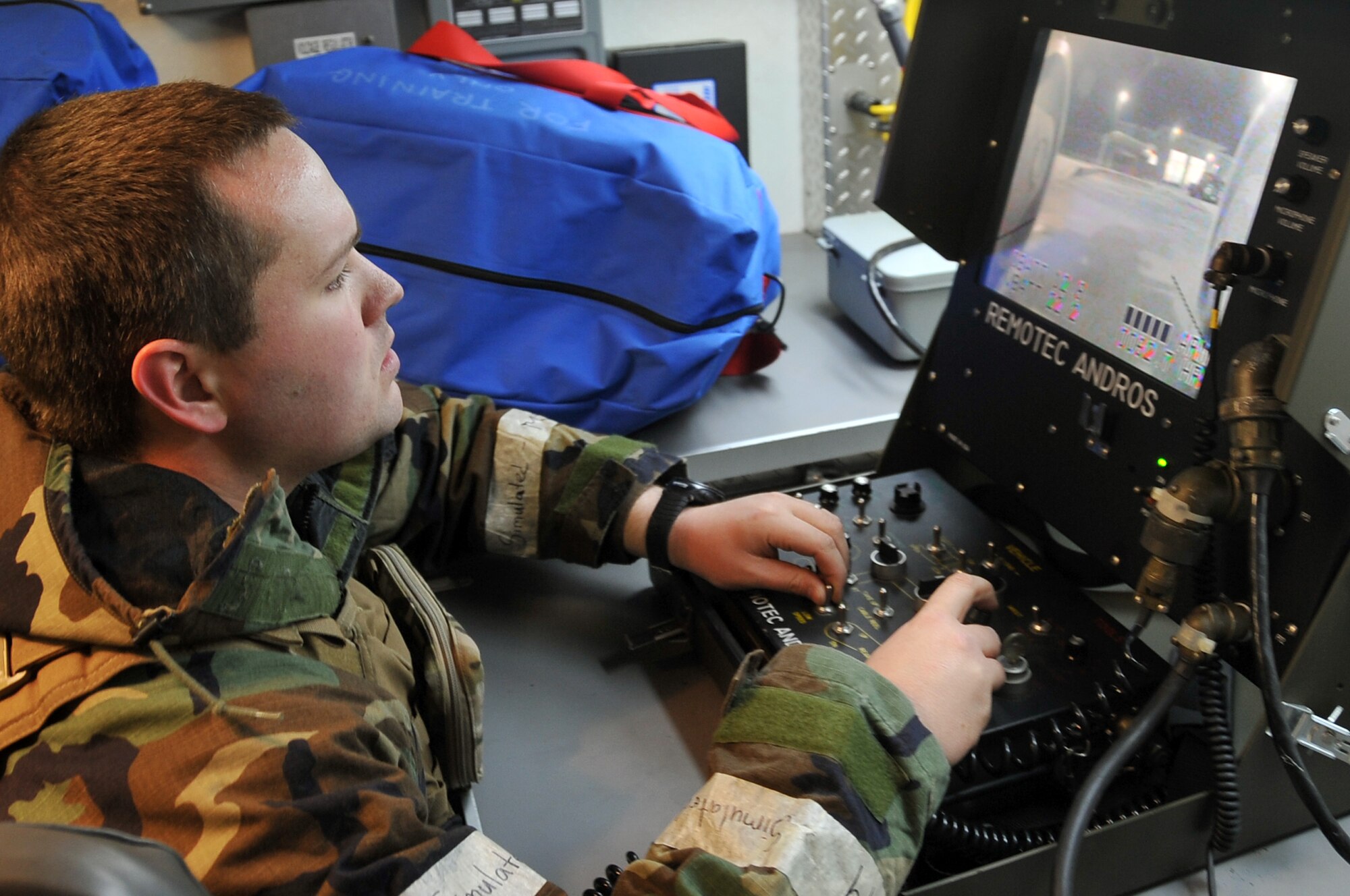 Senior Airman Matthew Workoff, 51st Civil Engineer Squadron, uses a remote control interface to operate the ANDROS F6 robot, Jan. 30, 2012. The Airmen are participating in a peninsula-wide operational readiness exercise, Beverly Bulldog 12-01, held to train U.S. forces throughout South Korea. (U.S. Air Force photo/Staff Sgt. Craig R. Cisek)
