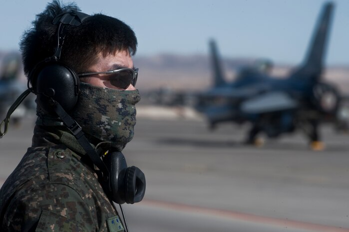A Republic of Korea Air Force Airman watches an F-15E Strike Eagle taxi to the runway during Red Flag 12-2 Jan. 27, 2012, at Nellis Air Force Base, Nev. Red Flag is a realistic combat training exercise involving the air forces of the United States and its allies. The exercise is hosted north of Las Vegas on the Nevada Test and Training Range. (U.S. Air Force photo by Airman 1st Class Daniel Hughes)